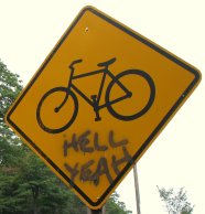 [Photograph of a bicycle warning sign with `Hell yeah' written on it]